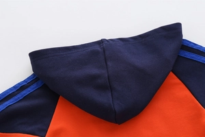 Detail des Kapuzen-Ausschnitts mit Kontrastfarben in Orange und Marineblau und Streifen