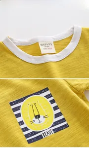 Détail d'un t-shirt jaune pour garçon en coton flammé avec imprimé lion et col rond