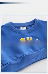 Detail view of cotton kids sweatshirt showing ribbed crewneck and size label