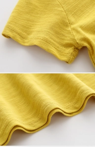 Détail du t-shirt en coton jaune montrant les coutures fines des manches et du bas
