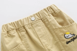 Detail of boys' khaki shorts showing elastic waistband and whale embroidery