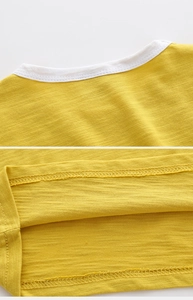 Détail du t-shirt jaune en coton flammé pour garçons montrant le col et l'ourlet