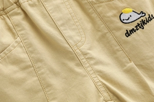 Close-up of cotton twill khaki shorts with elastic waist and whale embroidery