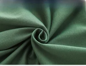 Gros plan détaillé sur la texture du tissu tricoté vert foncé d'un t-shirt enfant