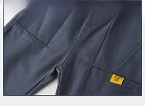 Detail shot of blue cotton casual trousers with neat stitching and yellow woven label
