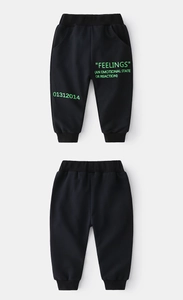 Détail du jogging noir pour enfant avec lettrage Feelings vert fluo et taille élastique
