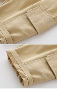 Detail of khaki cargo shorts showing contrast topstitching and flap pocket textures