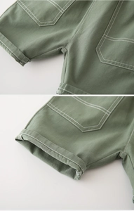 Détail de la double couture sur un short en coton vert pour garçon montrant la finition