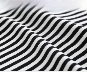 Macro shot of soft black and white striped knit fabric texture for boys polo shirts