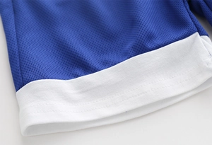 Détail du tissu en maille respirante bleue avec poignets en tricot blanc sur un ensemble