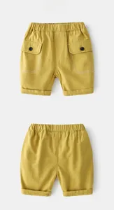 Detail of yellow kids cargo shorts featuring elastic waist and utility pockets with buttons