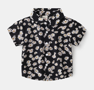 Close-up of black kids' short-sleeve shirt featuring white daisy print and white buttons
