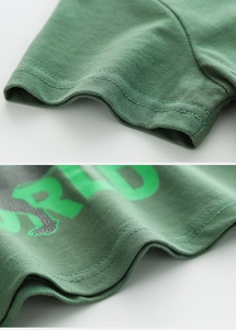 Détail de couture à double aiguille sur un t-shirt enfant en coton vert foncé