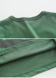 Détails du col ras du cou côtelé et de la double couture sur un T-shirt enfant en coton vert