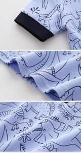Detail of dinosaur print fabric and ribbed sleeve cuff on light blue cotton polo shirt