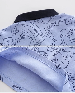 Detail of blue dinosaur print polo shirt showing breathable mesh fabric and fine stitching