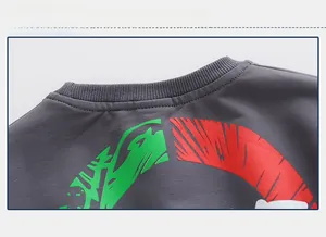 Détail du col rond côtelé sur un sweat gris foncé pour enfant avec des motifs imprimés