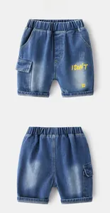 Detailed view of kids denim shorts featuring elastic waist and yellow graphic prints