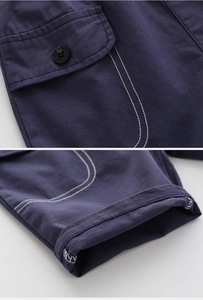 Detail of dark blue cargo shorts showing heavy cotton fabric, pocket and contrast stitching