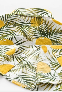 Detail of tropical citrus print kids shirt showing collar stitching and white buttons