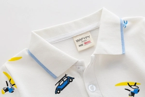 Dettaglio della polo bianca da bambino con colletto a righe blu e ricamo a cartone