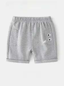 Close-up of kids grey cotton shorts featuring cartoon tooth pocket and elastic waist