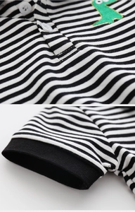 Detail of boys striped polo shirt with cute dinosaur embroidery and ribbed cuffs