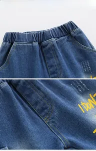 Close-up of elastic waistband and yellow letter prints on dark blue denim shorts