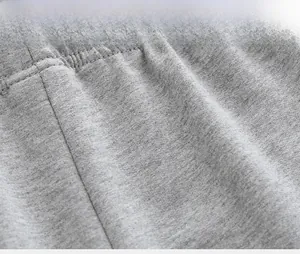 Detailed macro view of gray knitted fabric and elastic waistband stitching for boys shorts