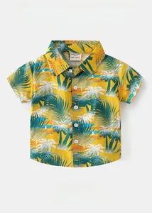 Detailed flat lay of boys yellow Hawaiian shirt with palm tree prints and button-up collar
