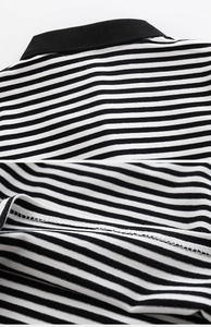 Detail of boys' striped polo shirt showing black ribbed collar and precise stitching