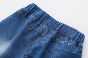 Détail de la taille élastique d'un short en jean enfant avec coutures jaunes renforcées