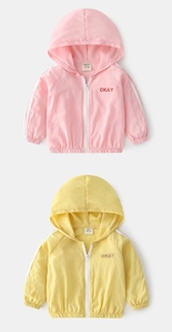 Detail of kids hooded sun protection jackets in pink and yellow with 'OKAY' print