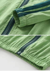 Detail of light green sun-protective jacket showing elastic cuffs and durable zip closure
