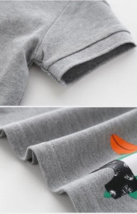 Detailed close-up of grey piqué cotton polo shirt sleeve cuff and cartoon screen print