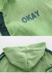 Detail of green kids hooded sun jacket with OKAY print and textured breathable fabric