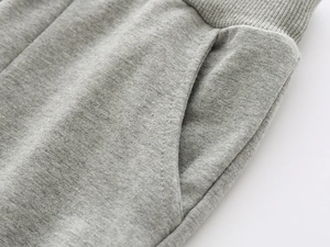 Detail view of boys gray joggers showing elastic waistband and stitching on soft fabric