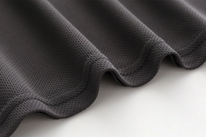 Macro view of dark grey breathable mesh fabric with durable double-needle stitching
