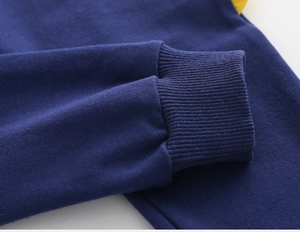 Dettaglio dei pantaloni sportivi blu scuro con polsini a coste elastici e cuciture rifinite