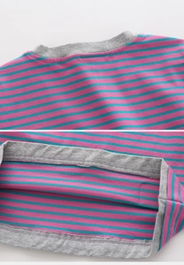 Detail of colorful striped knit fabric showing fine double-needle stitching on the hem