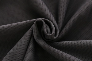 Macro shot of breathable mesh fabric texture on kids sports t-shirt showing weaving detail