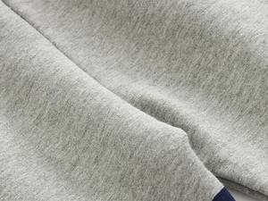 Detailed macro view of soft gray melange knitted fabric on boys' sports trousers