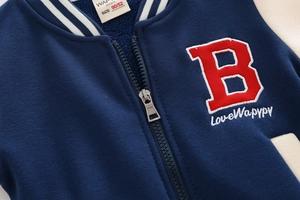 Close-up of navy boy's baseball jacket featuring 3D letter embroidery and rib knit collar