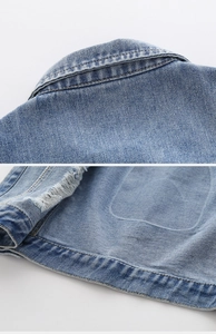 Dettaglio dell'orlo usurato e cuciture del colletto su gilet in denim azzurro bimbo