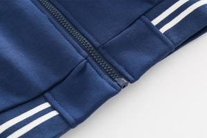 Detailed close-up of navy blue boy's jacket featuring a smooth zipper and ribbed hem