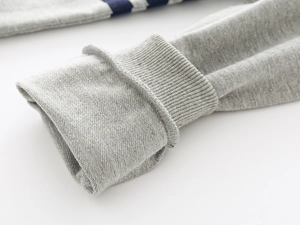 Close-up of gray ribbed cuffs on casual kids knit sweater with striped details