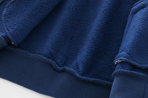 Macro shot of navy fleece fabric texture and elastic ribbed cuff on boys zip jacket