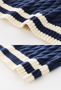 Detailed cable knit pattern on navy blue sweater vest with white ribbed trim detail