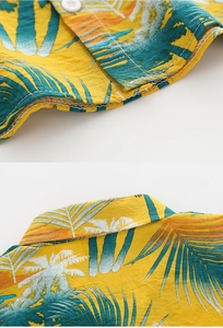 Detail of yellow tropical palm tree print and white button on cotton linen shirt