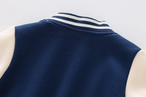 Detail of ribbed knit collar on navy and cream boys' varsity jacket with stripe accents